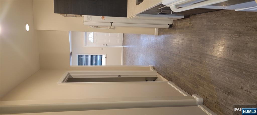 196 Fort Lee Road Teaneck, NJ 07666 - Photo 11 of 13 an empty room with a fireplace and wooden floor