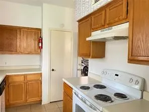a white kitchen with a sink and a refrigerator
