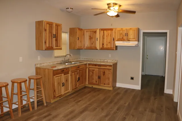 a kitchen with a sink cabinets and wooden floor