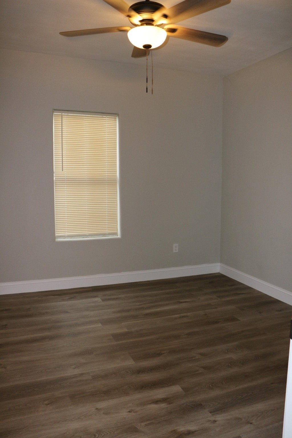 1014 West 4th Street Freeport, TX 77541 - Photo 13 of 16 a view of an empty room with wooden floor and a window