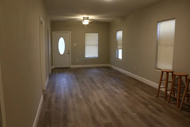 wooden floor in an empty room with a window