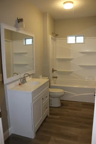 a bathroom with a sink a toilet and shower