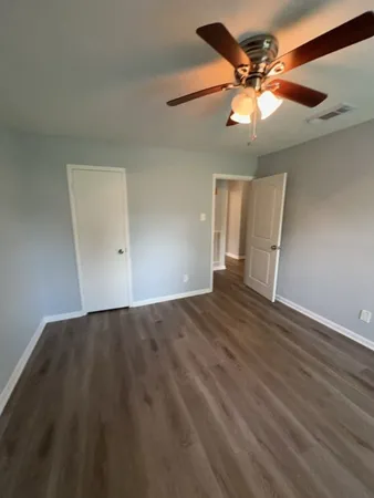 a view of an empty room with a chandelier fan