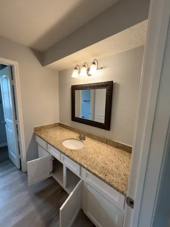 a bathroom with a granite countertop sink and mirror