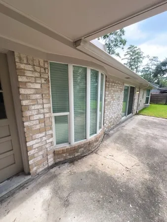 a view of backyard with large window and front door