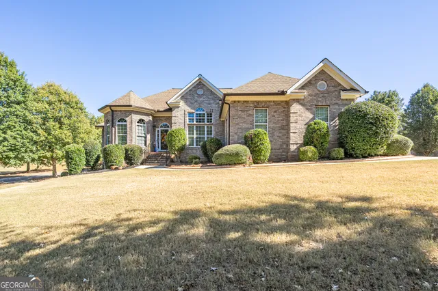 a front view of a house with a yard and potted plants