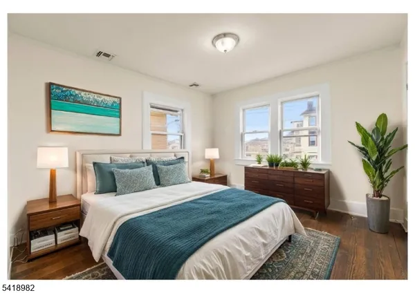 a bedroom with a large bed and a potted plant