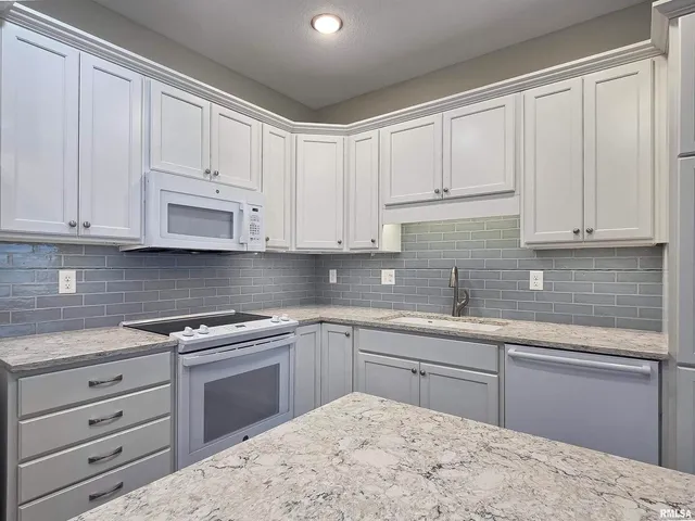 a kitchen with cabinets appliances and a sink