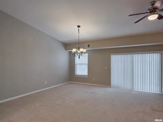 an empty room with windows and chandelier
