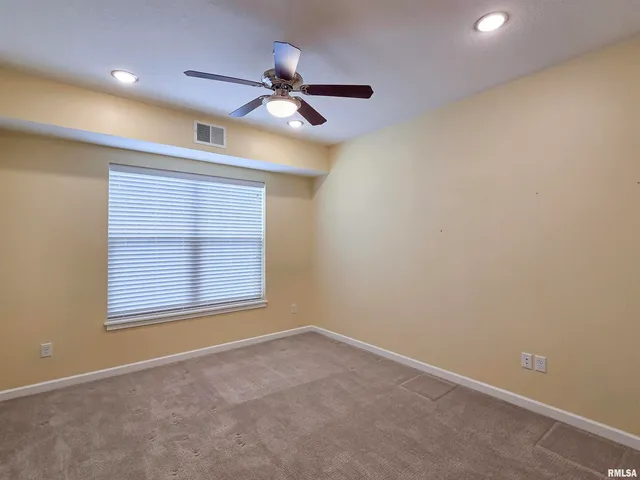 an empty room with a ceiling fan and closet