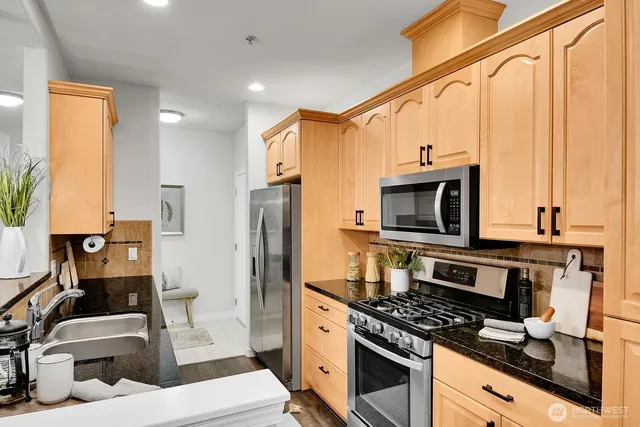 a kitchen with stainless steel appliances a stove a sink and a microwave