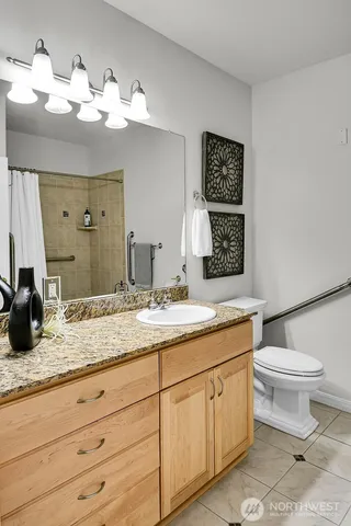 a bathroom with a granite countertop sink mirror and toilet