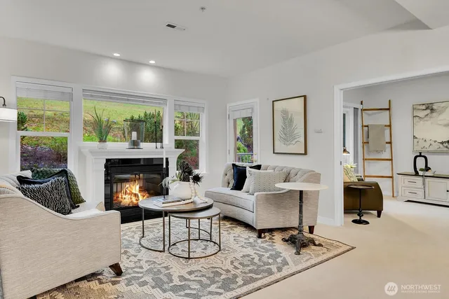 a living room with furniture fireplace and a large window
