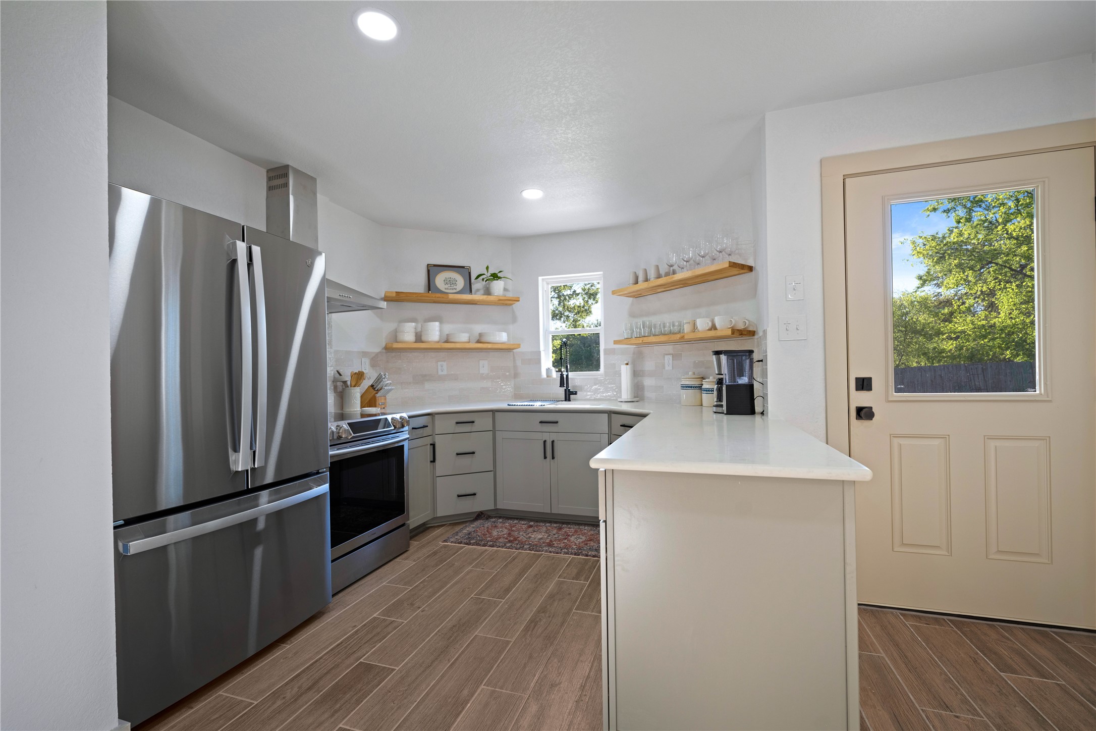 131 Campfire Circle Wimberley, TX 78676 - Photo 11 of 40 a kitchen with stainless steel appliances a refrigerator sink and wooden floor