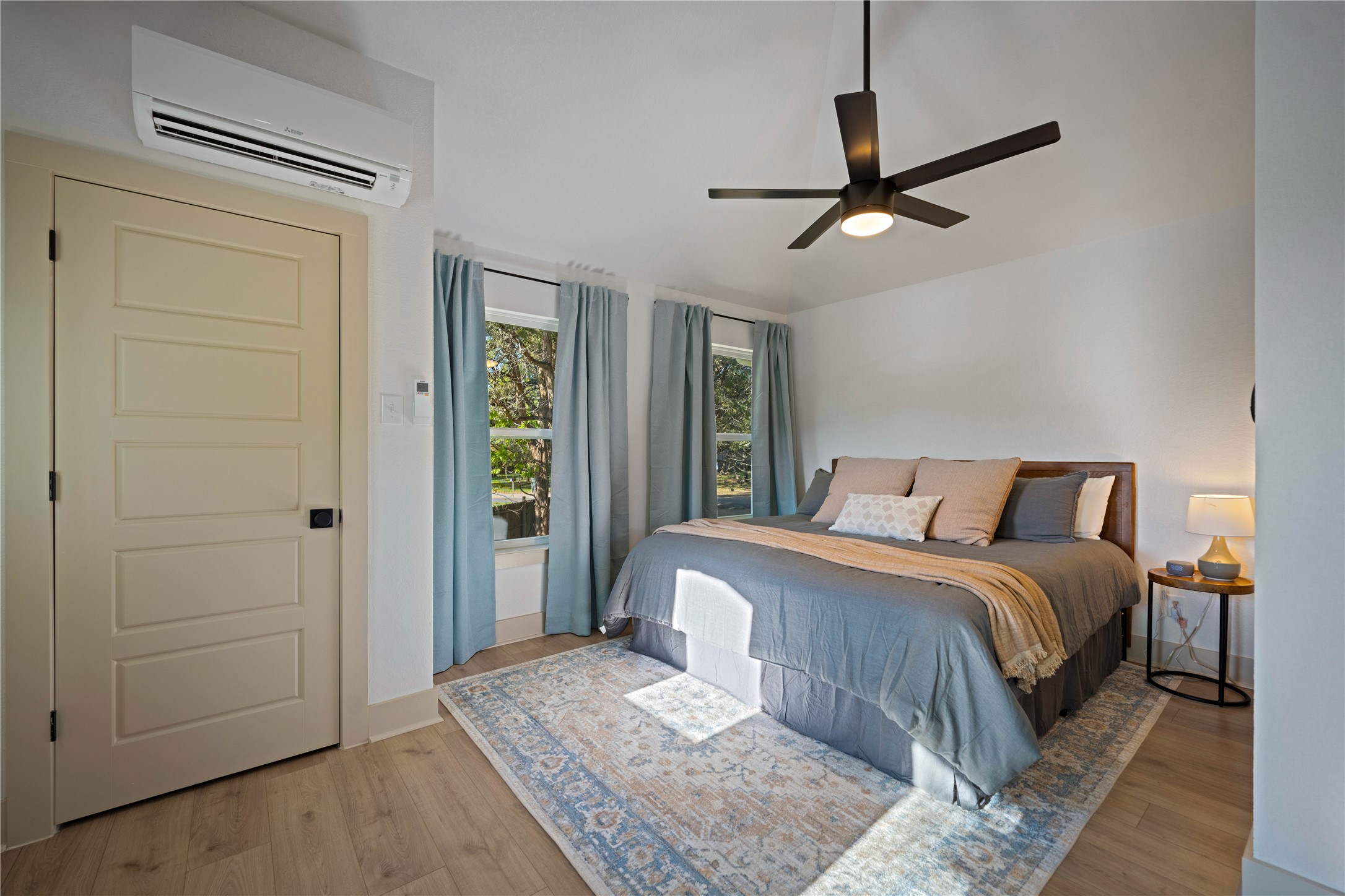 131 Campfire Circle Wimberley, TX 78676 - Photo 20 of 40 a bedroom with a large bed and a chandelier