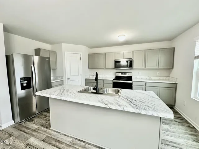 a kitchen with stainless steel appliances granite countertop a refrigerator stove a sink and dishwasher