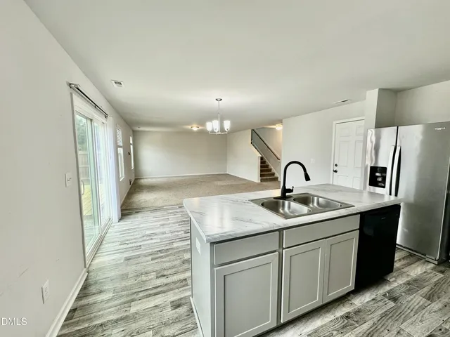 a kitchen with stainless steel appliances granite countertop a sink and a refrigerator