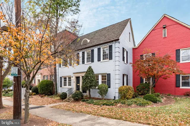 a front view of a house with a yard and tree s