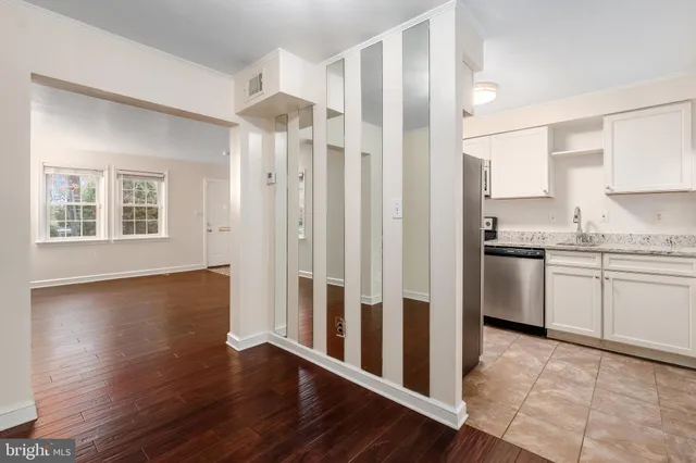 a kitchen with granite countertop a refrigerator sink and cabinets