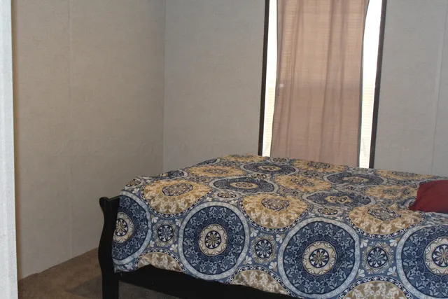 a bed sitting in a bedroom next to a window