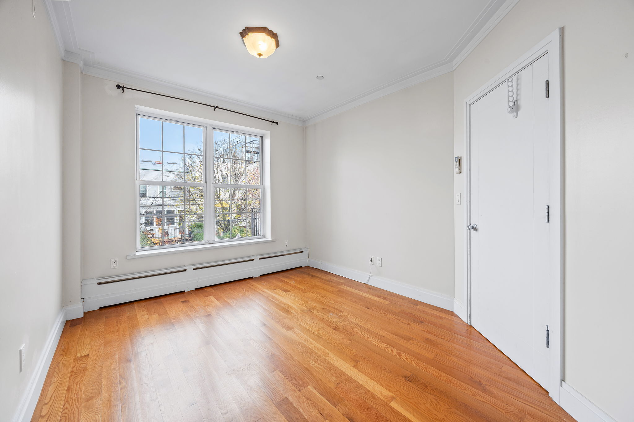 175 12th Street, Unit 2B Brooklyn, NY 11215 - Photo 16 of 20 a view of an empty room with a window and wooden floor