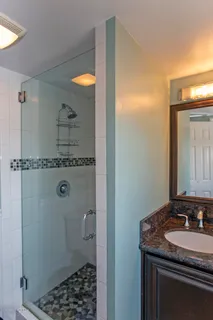 a bathroom with a granite countertop sink and a mirror