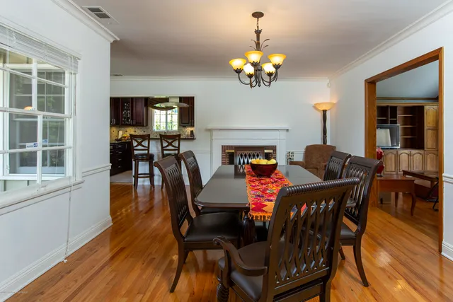 a view of a dining room with furniture a chandelier and wooden floor