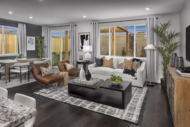 a living room with furniture large window and a table