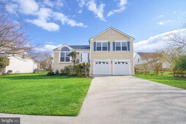 a view of house with a big yard and potted plants in front of main door