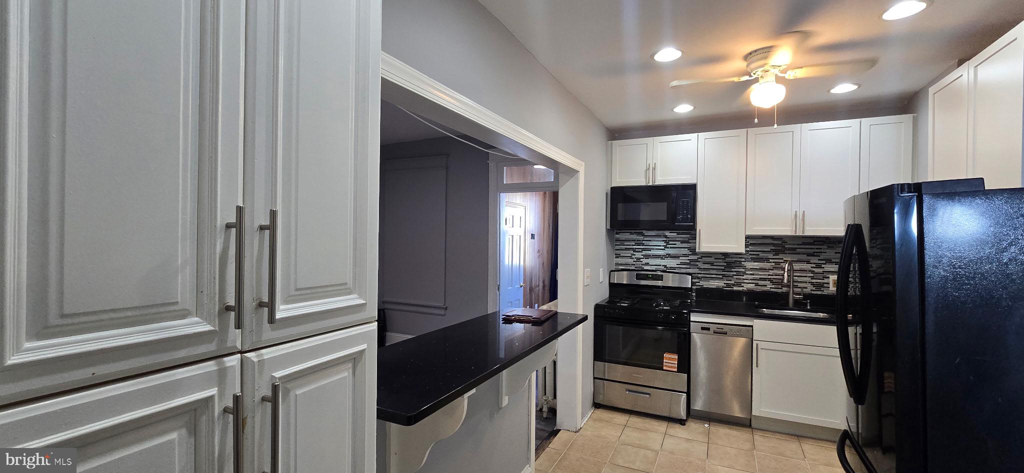 735 Princeton Place Northwest Washington, DC 20010 - Photo 4 of 11 a kitchen with stainless steel appliances granite countertop a stove and a refrigerator