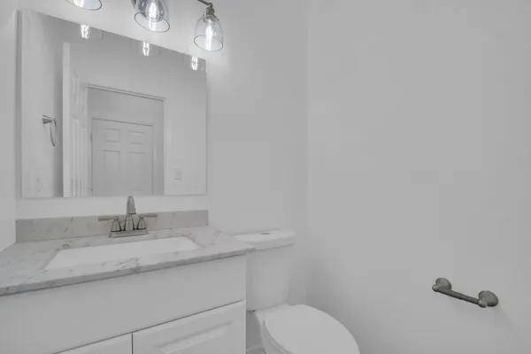 a bathroom with a granite countertop sink a toilet and a mirror