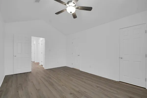 a view of an empty room with wooden floor