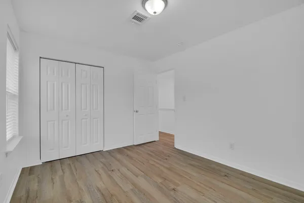 a view of an empty room with wooden floor