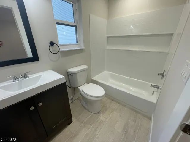 a bathroom with a toilet a sink a mirror and a shower