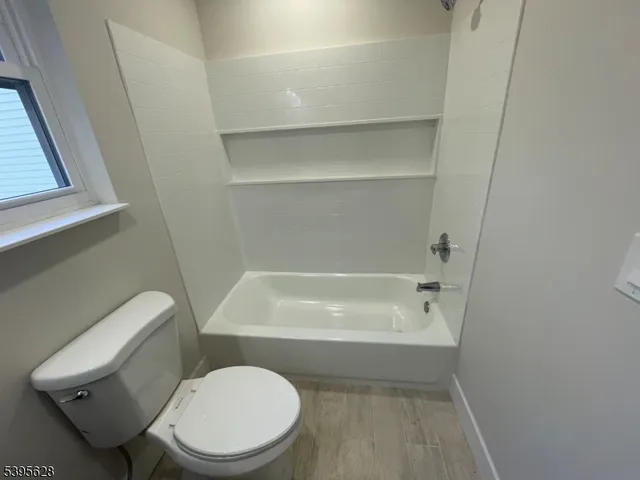 a white toilet sitting next to a bath tub
