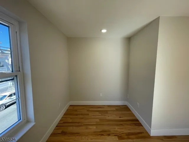 a view of a room with wooden floor and a window