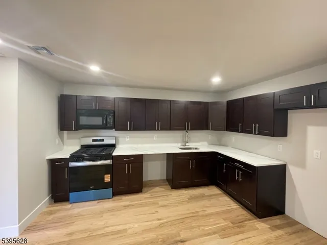 a large kitchen with stainless steel appliances kitchen island granite countertop a sink and cabinets