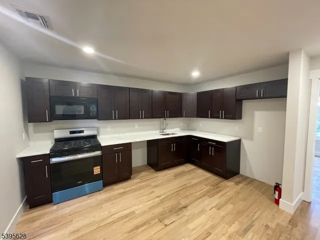 a kitchen with stainless steel appliances granite countertop a refrigerator a sink dishwasher a stove and a refrigerator