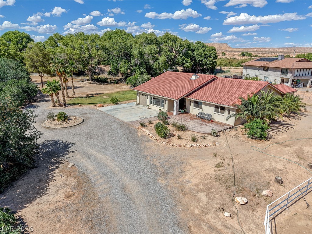 1950 Bowman Road Logandale, NV 89021 - Photo 64 of 81 A terracotta-roofed residence nestled in a desert landscape, boasting a circular driveway and mature foliage.