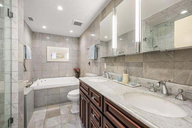 a bathroom with a granite countertop sink a toilet and bathtub