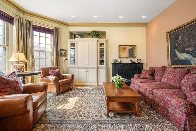 a living room with furniture fireplace and a large window