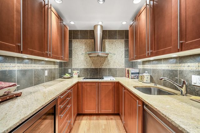 a kitchen with stainless steel appliances granite countertop a sink a stove and cabinets