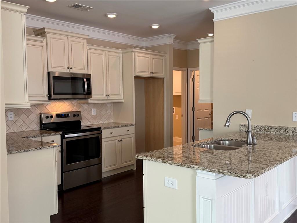 3329 Ivy Ridge Court, Unit 791 Buford, GA 30519 - Photo 13 of 36 a kitchen with stainless steel appliances granite countertop a stove a sink and a microwave
