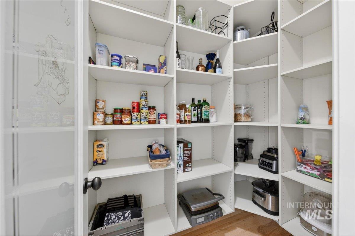 414 East Shafer View Drive Meridian, ID 83642 - Photo 13 of 50 Walk-in pantry 8x4 featuring extensive white shelving, integrated corner units, and a custom decorative glass door