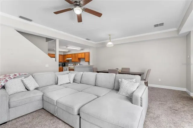 a living room with furniture and a ceiling fan