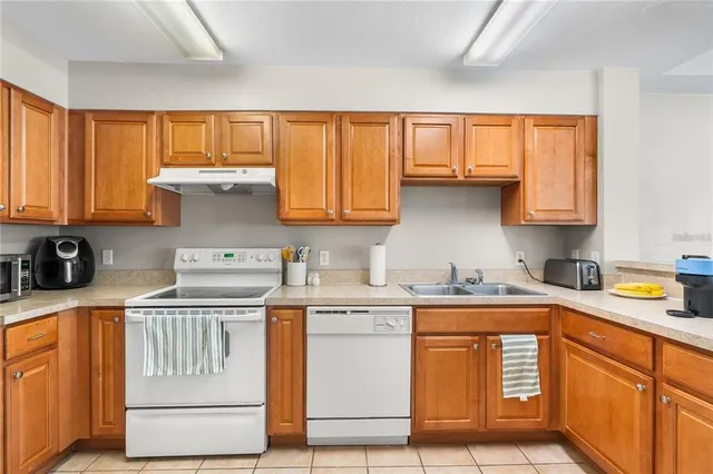 a kitchen with stainless steel appliances granite countertop a stove a sink and white cabinets