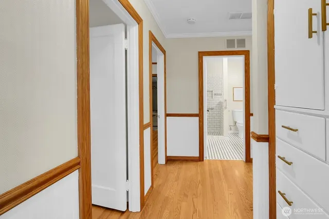 an empty room with wooden floor and a bathroom