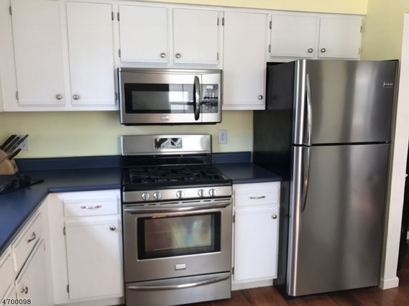 41 Rhea Run Newton, NJ 07860 - Photo 4 of 17 a kitchen with stainless steel appliances white cabinets white stove a microwave and a refrigerator