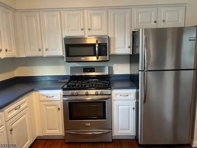 a kitchen with white cabinets and stainless steel appliances