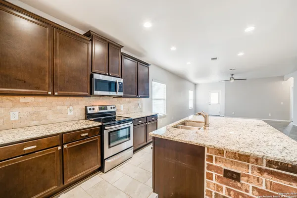 a kitchen with stainless steel appliances granite countertop a sink stove and oven